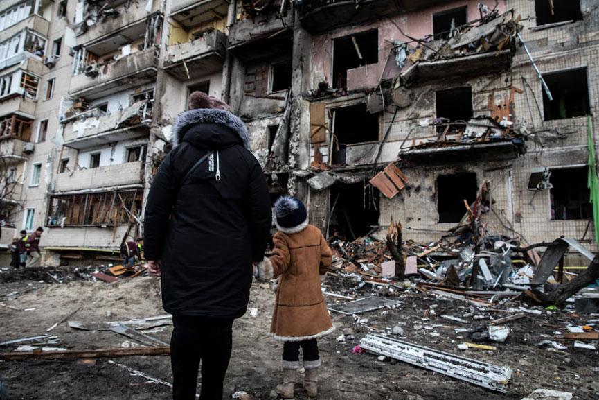 一对母女站在基辅被摧毁的公寓门前。来源：《华盛顿邮报》